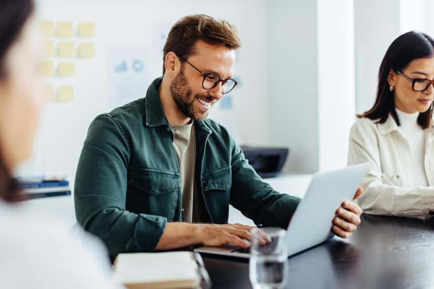 Designer using a laptop while sitting in a meeting